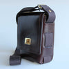 Brown leather bag with a gold clasp with 100% heavy cotton webbing woven down sides of bag