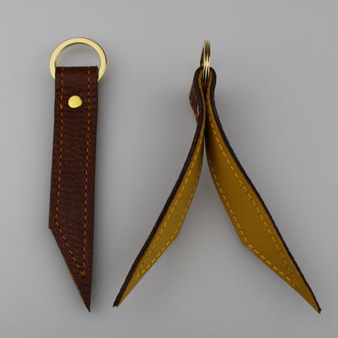 Elegant leather keyrings to keep your keys secure and easily accessible. Hand-crafted from British full-grain leather,  two-toned for striking effect.  Features  Ribbon shaped keyring Hardware in brass Lined in soft leather made by Sam Brown London Wiltshire UK